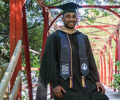 A veteran man wearing a gown and veterans stole on the UIW campus.